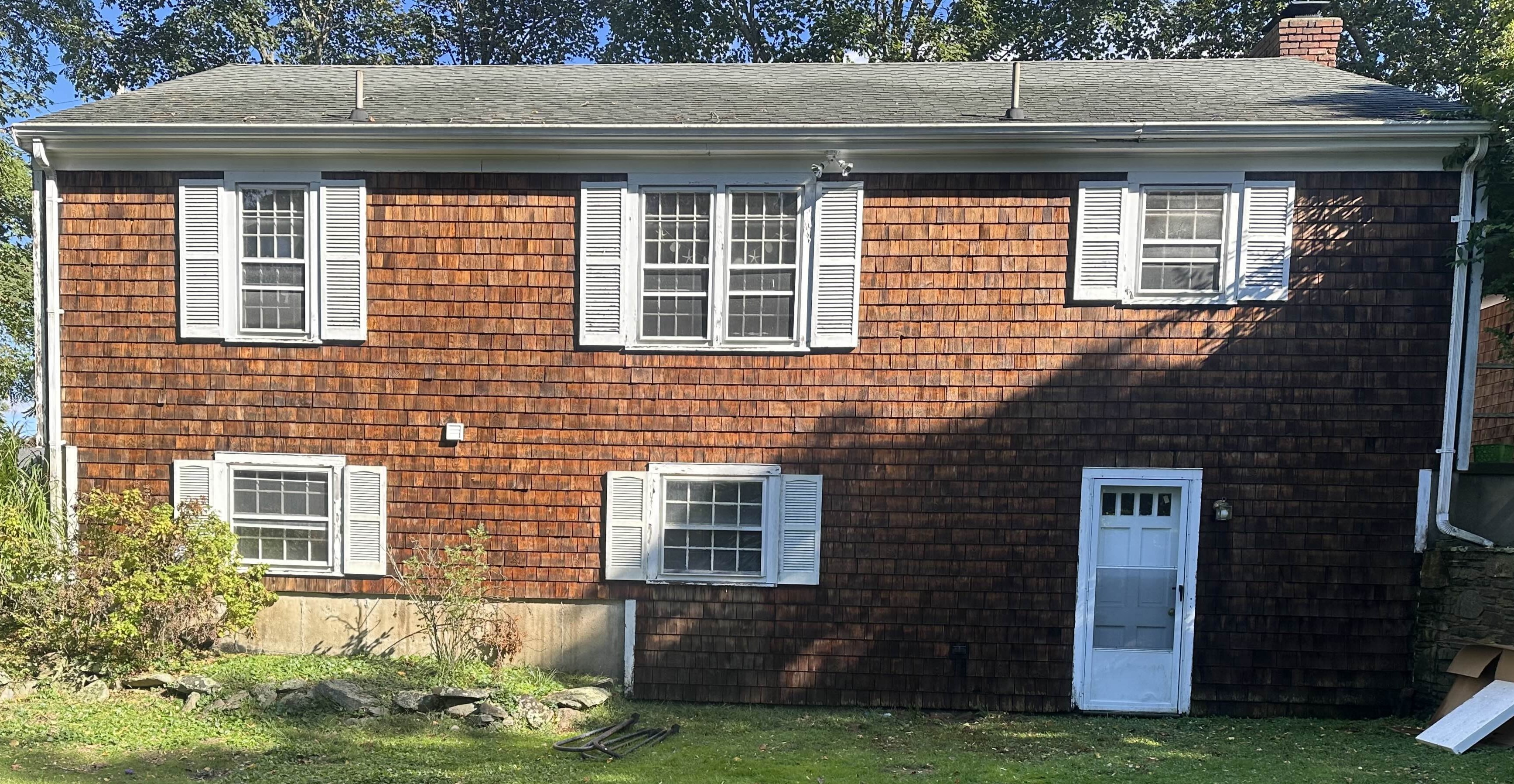 Cedar shake siding back of house after professional cleaning Middletown RI - restored warm natural cedar tones