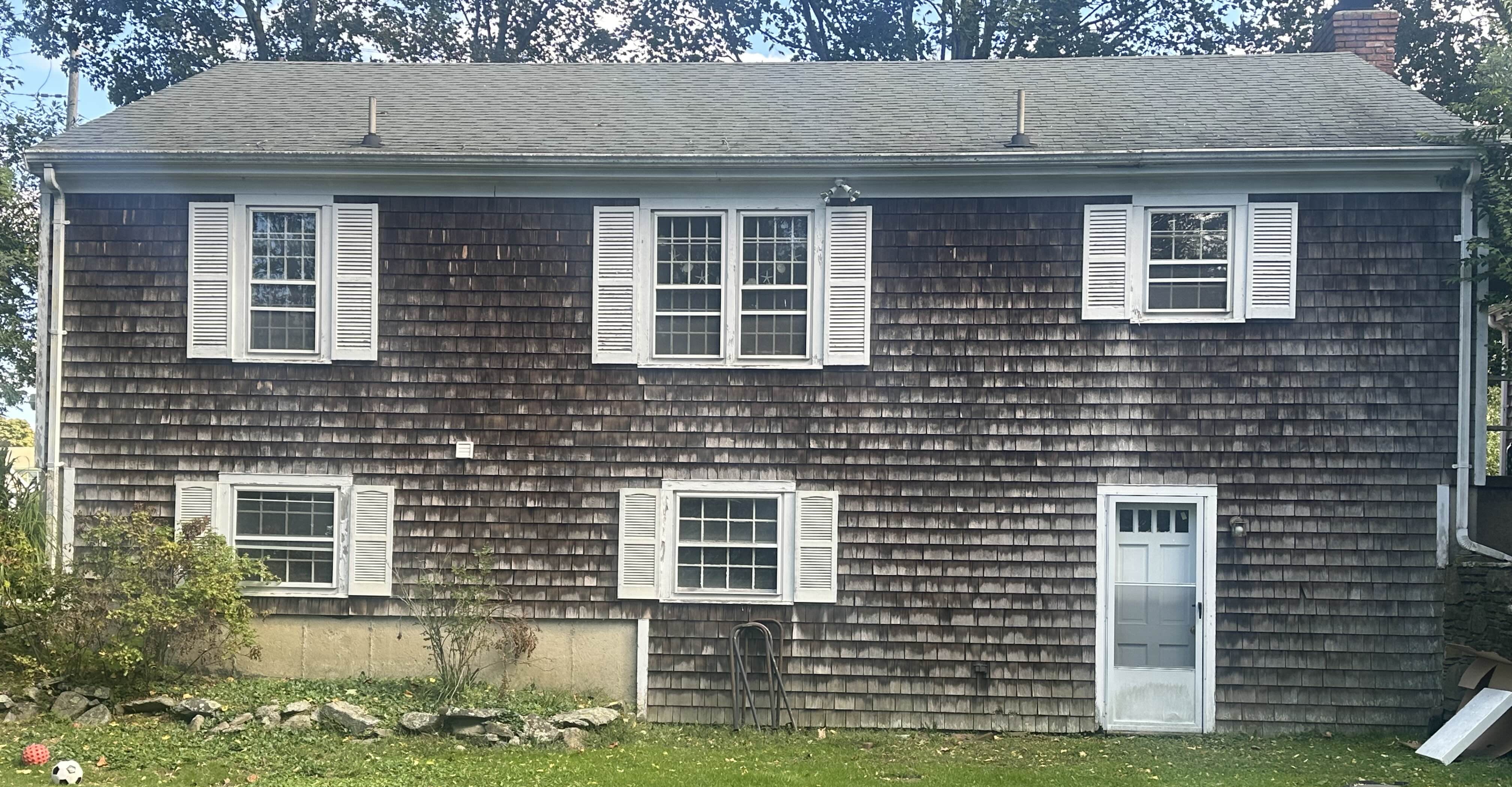 Cedar shake siding back of house before cleaning Middletown RI - severely weathered gray appearance
