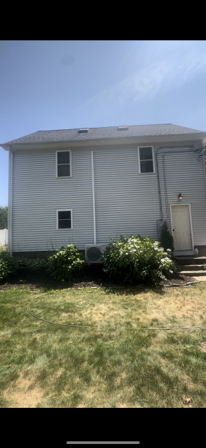 Two-story house vinyl siding after professional cleaning Bradford RI - restored bright white appearance